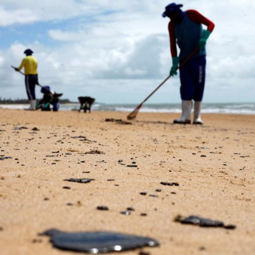 As pessoas removem um derramamento de óleo na praia de Coruripe, estado de Alagoas, Brasil, 14 de outubro de 2019. REUTERS / Adriano Machado